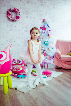 Child looks funny posing in ballet-dancers dress in play-room