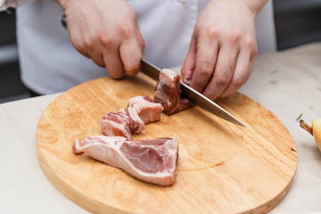Chef Cutting Raw Meat on The Wood Block.