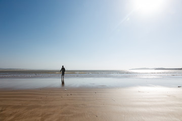 Naklejka premium Young boy running on ocean beach wants to catch a ball from water