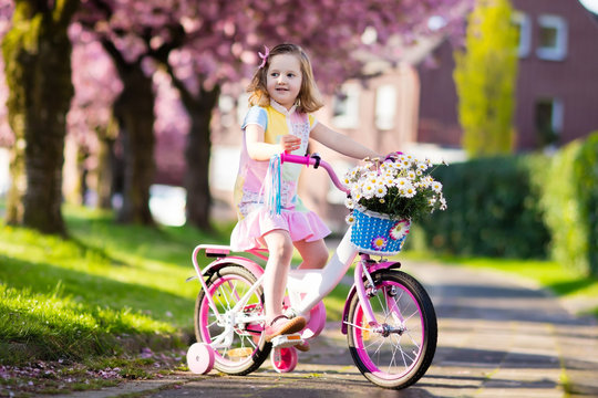 Little girl riding a bike. Child on bicycle.