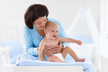 Mother changing diaper to baby boy