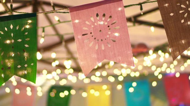 Slow motion shot of Colorful festival flags at night with garland light bokeh decoration