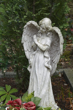 betende engelsfigur steht auf einem grab