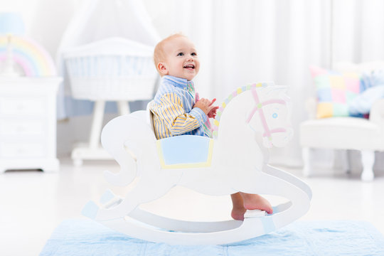 Baby boy in rocking horse toy