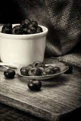 Pot of blueberries with spoon on a rustic background