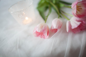 Textile wedding background with pink tulips and candle. woman's day