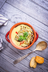 Homemade vegetable healthy cream soup with cauliflower, zucchini, pine nuts and pumpkin oil