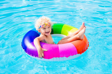 Child with toy ring in swimming pool