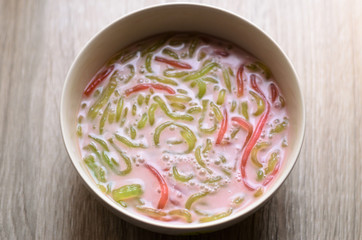 Thai dessert,Bowl of dessert made of flour rice with coconut milk on wooden table,flavor sweet asian style