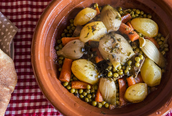 Fototapeta na wymiar tajin piatto tipico marocchino con patate carote e varie verdure accompagnato con il pane