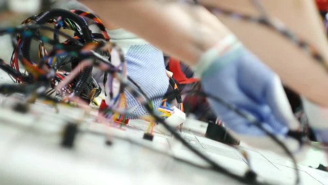 factory worker hands are working on machine and connecting electrical wires
