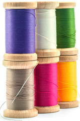 Isolated wooden spools of thread with a needle