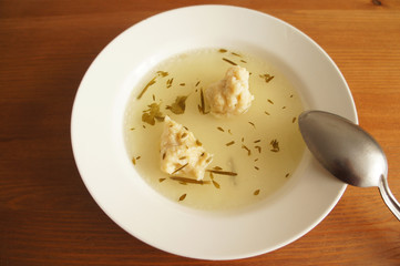 Chicken broth in white plate on wood background