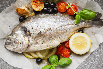 fish gilt-head Bram, cooked in a pan with vegetables and lemon, black olives. fresh basil . Healthy lunch