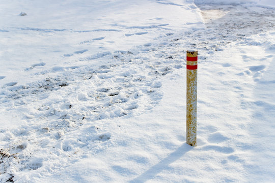 Snow traces pillar on the road
