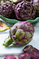 Fresh big Romanesco artichokes green-purple flower heads ready to cook