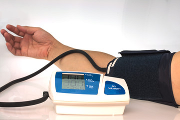 Man is checking blood pressure using home blood pressure monitor