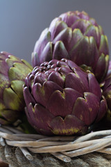 Obraz premium Fresh big Romanesco artichokes green-purple flower heads ready to cook