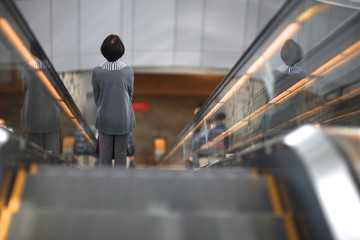 A woman on an escalator in a mall. Japan.