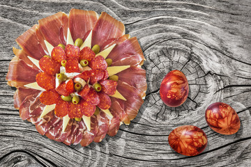 Serbian Traditional Appetizer Savory Dish Meze with Colorful Easter Eggs Set on Old Weathered Cracked Knotted Pine Wood Table Surface