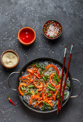 Starch (rice, potato) noodles with vegetables - bell peppers, carrots, green beans, onions, sesame seeds and soy sauce. Vegetarian dish. A delicious dinner in the Asian style
