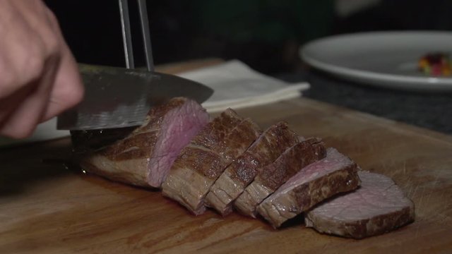 Stake sliceingand Chef Garnishing Dish At Counter