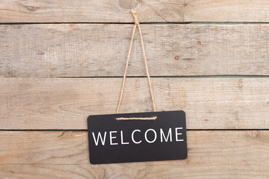 Blackboards with inscription "Welcome" on wooden background