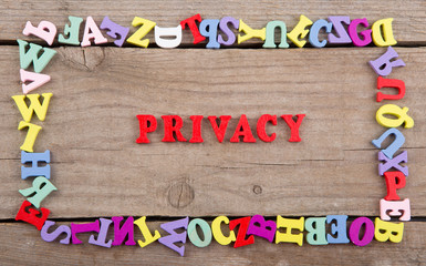 Text "Privacy" of colored wooden letters on a wooden background