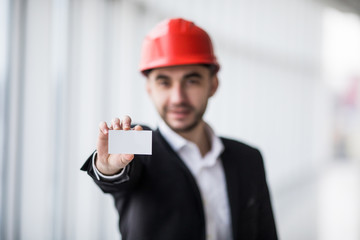 Construction worker holding blank business card in building construction.