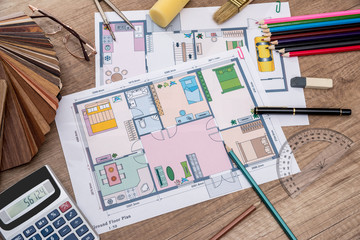 individual plan of house with wooden samples, pencil on desk.