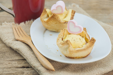Egg cheese bread toast on white dish with wooden fork and red coffee mug and heart marshmallow background