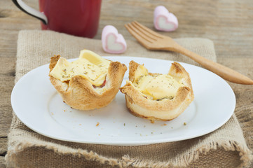 Egg cheese bread toast on white dish with wooden fork and red coffee mug and heart marshmallow background