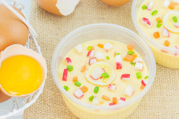 Thai steamed egg with fresh beaten egg decoration on sack background