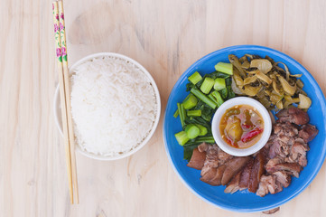 Stewed pork leg set with rice and chopsticks over wooden table