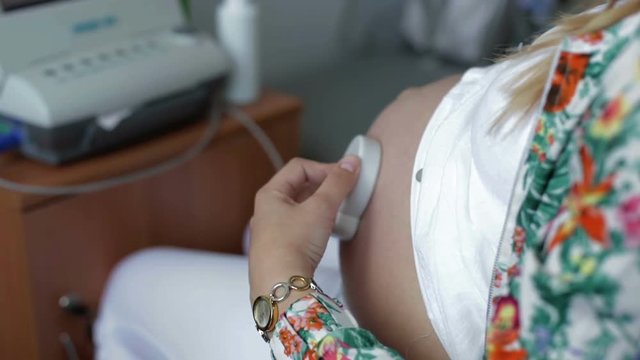 Pregnant woman makes check the baby's heartbeat on the belly .