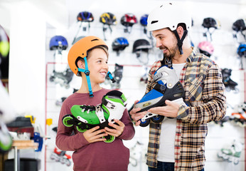 father and son deciding on new roller-skates in sports store