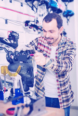 Male master fixing roller-skates in sports store