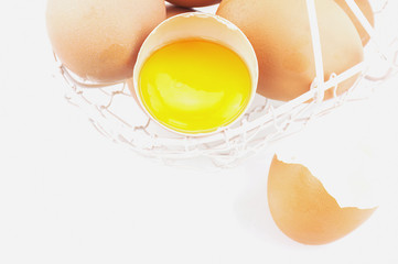 Egg and broken egg basket on white background