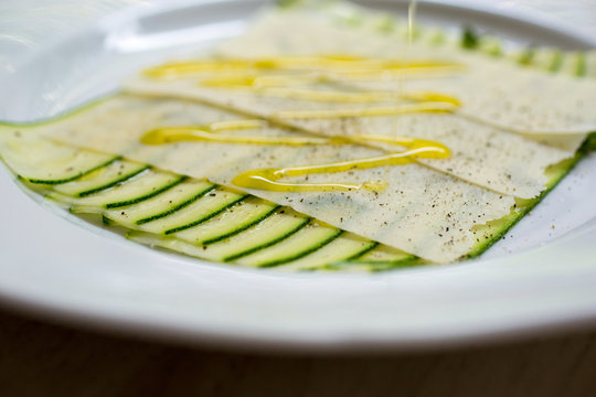 Courgette carpaccio on plate with drizzle of dressing