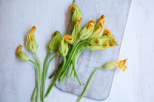 Overhead view of squash blossom flowers on cutting board