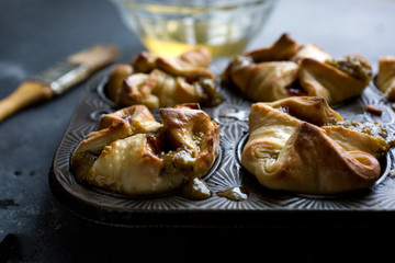 Pistachio buns with rose and strawberry in baking tray, close-up
