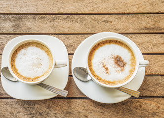 Couple of coffee cup over brown plank wood table