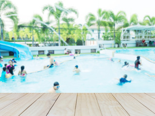 Blur of people playing in a swimming pool fun park with white wood terrace