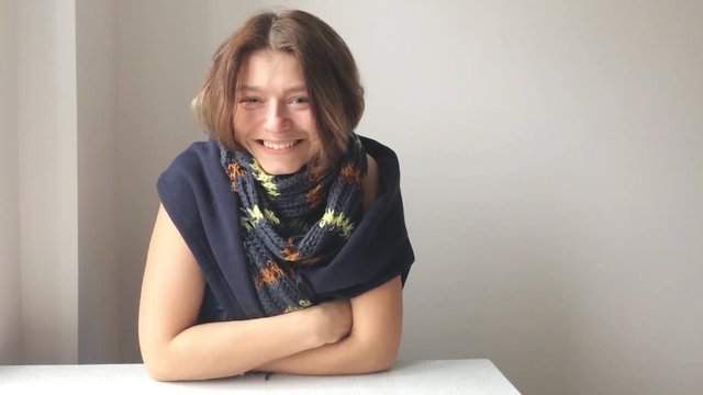 Portrait of a cute girl with blond hair in a scarf. Close-up