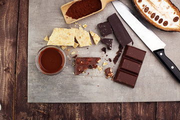 Melting chocolate and diffrent bars - stack and chips with chocolate swirl/ powder and cocoa pod with melted chocolate
