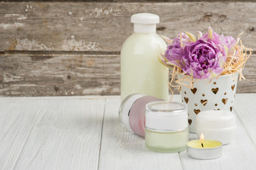 Fototapeta na wymiar Beauty products, cosmetics, lit candle and purple tulips