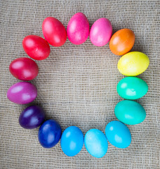 Colorful easter eggs round frame on sackcloth background
