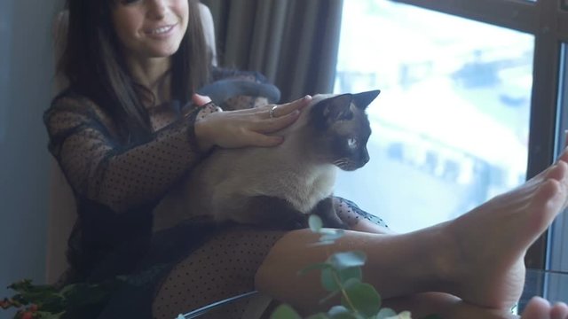 Brunette female sitting with a cat