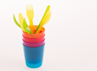 Multi-colored disposable plastic cups and forks and spoons