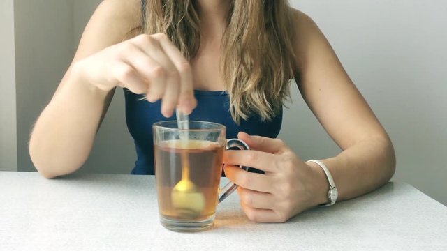 Female hands close up holding cup of hot tea